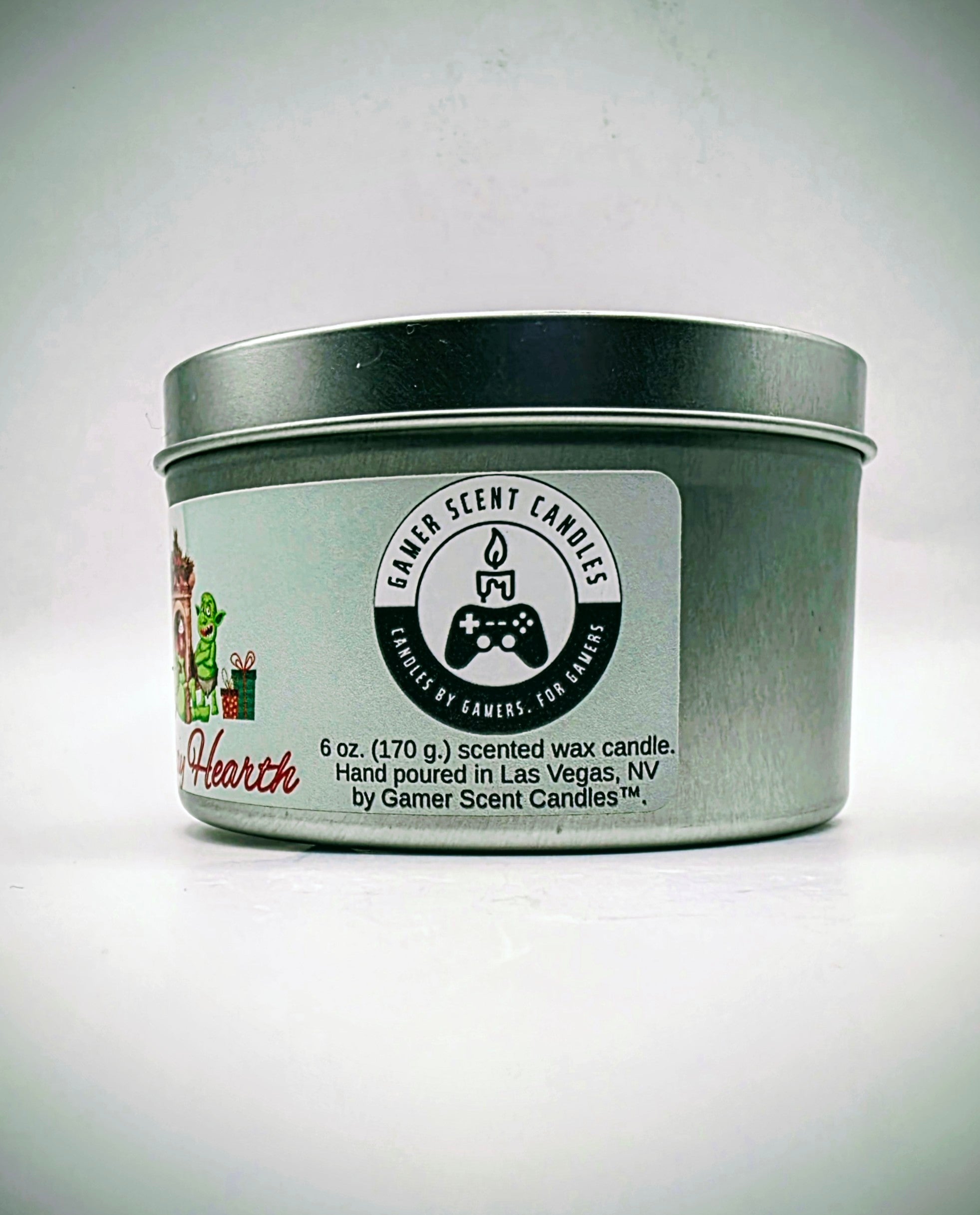 A 6 oz. candle in a candle tin named "Holiday Hearth" featuring a festive gathering of orcs around a fireplace during the holiday season.