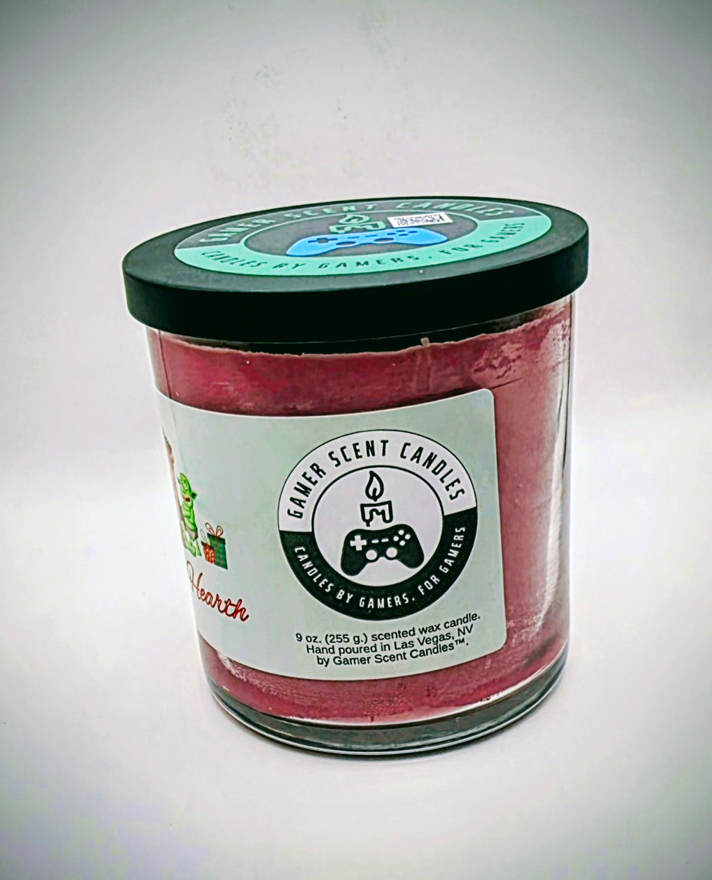 A 9 oz. candle in a glass tumbler jar named "Holiday Hearth". The label features a festive gathering of orcs around a fireplace during the holiday season.