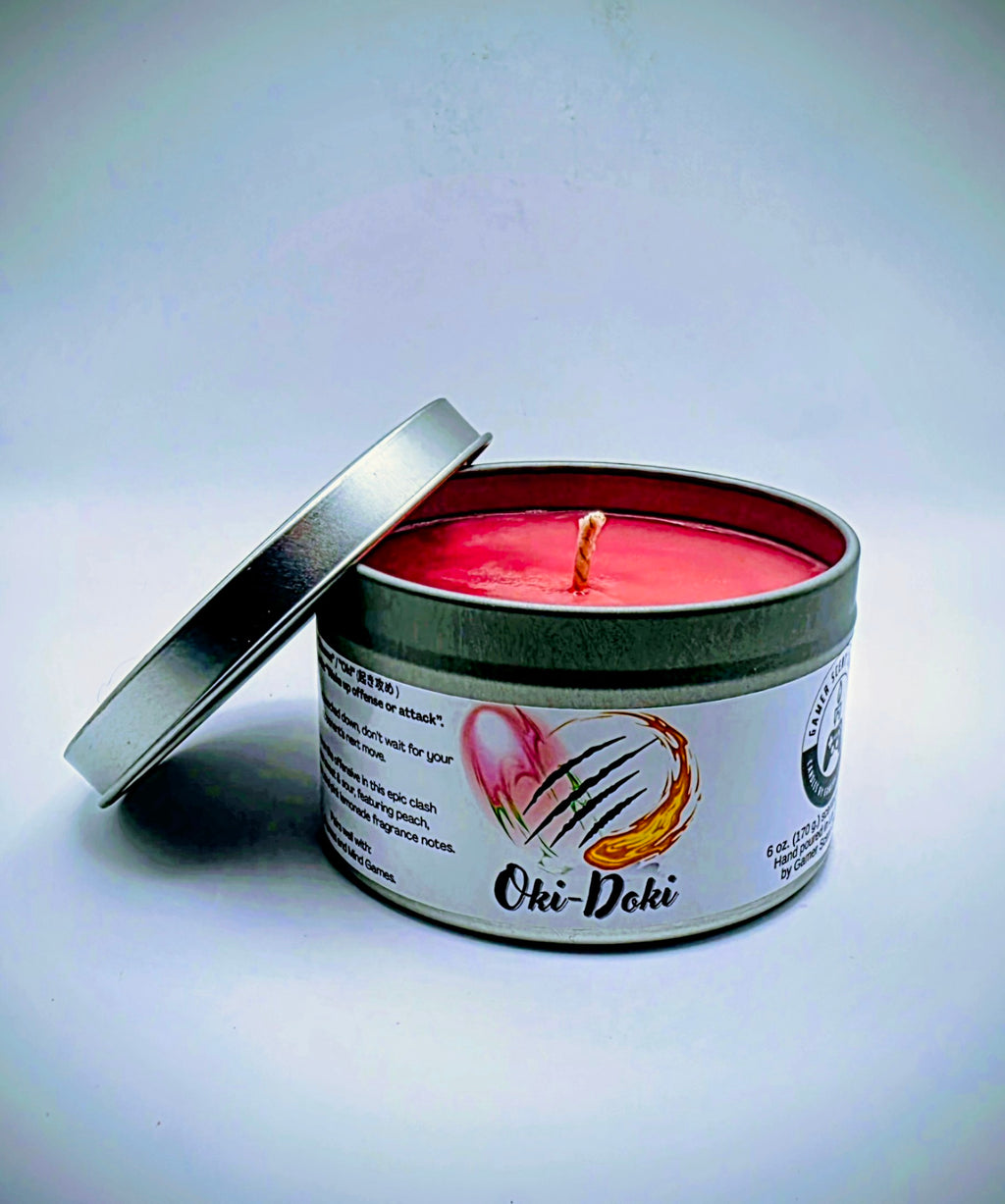 Our Oki-Doki candle in a candle tin. It has a net weight of 6 oz. and approximately a 25 hour burn time. It features a mixture of sweet and sour fragrance notes including peach, watermelon, and pink lemonade. The clash between sweet and sour is meant to represent the clash between powerful fighters in your favorite fighting game franchises. The label is white with images reminiscent of the fireball and slashing attacks featured in many fighting games.